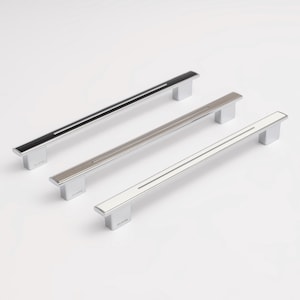 Peut inclure: Trois poignées de placard linéaires avec un profil rectangulaire et une rainure centrale. Les poignées sont en chrome poli avec des inserts centraux contrastants en noir, nickel brossé et blanc. Chaque base porte l'inscription ELIAVA.
