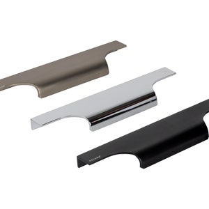 Può includere: Tre moderne maniglie per mobili in diverse finiture: nichel spazzolato, cromo e nero opaco. Ogni maniglia ha un design elegante e minimalista con un'impugnatura curva e una base piatta e rettangolare. Facili da installare.