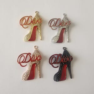 May include: Four high heel shoe charms with the word "Diva" written on them. The charms are in four different colors: gold, silver, black, and red.