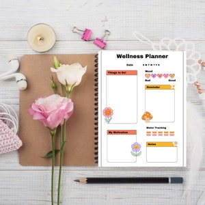 May include: A wellness planner with a colorful floral and mushroom design. The planner includes sections for daily tasks, mood tracking, water intake, and motivation. The planner has a white background with orange, yellow, and pink accents.