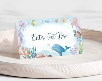 May include: A light blue place card with a watercolor design of sea creatures, including a whale, seahorse, jellyfish, and starfish. The text "Enter Text Here" is in the center of the card.