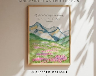 Könnte beinhalten: Handgemachter Aquarelldruck in einem Holzrahmen. Das Kunstwerk zeigt eine Berglandschaft mit blauen und grünen Farbtönen, ein Feld mit rosa Blumen und handschriftlichem Text. Der Text lautet: „Mein Gott aber wird all eurem Mangel abhelfen nach seinem Reichtum in der Herrlichkeit in Christus Jesus“.