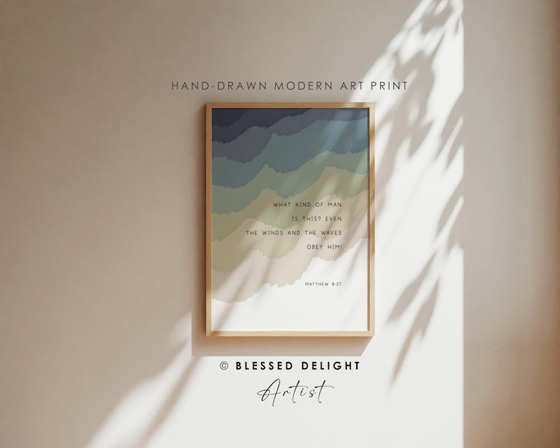 May include: A framed art print featuring layered, wavy bands of color transitioning from dark blue to light beige. The text reads: WHAT KIND OF MAN IS THIS? EVEN THE WINDS AND THE WAVES OBEY HIM! MATTHEW 8:27. The print is displayed in a light wood frame.