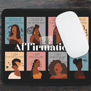 May include: A black mouse pad with a colorful design featuring illustrations of women and positive affirmations. The text on the mouse pad reads "Daily Affirmations".