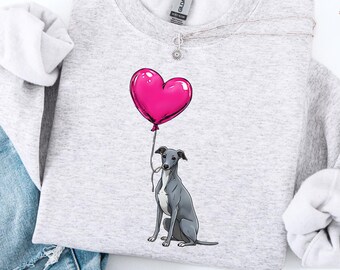 Könnte beinhalten: Hellgraues Sweatshirt mit einem Aufdruck eines grauen Hundes, der einen rosa herzförmigen Ballon hält. Das Sweatshirt wird mit blauen Jeans kombiniert. Das Design ist auf einem weichen, bequemen Stoff gedruckt.