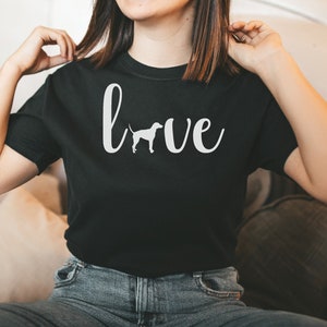 May include: A black t-shirt with a white graphic that says "love" with a silhouette of a dog in the "o".