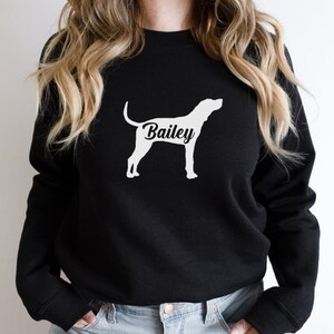 May include: Black sweatshirt with a white silhouette of a Bloodhound dog and the name "Bailey" printed on the chest.