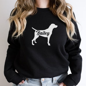 May include: Black sweatshirt with a white silhouette of a dog and the name "Bailey" printed on the front.