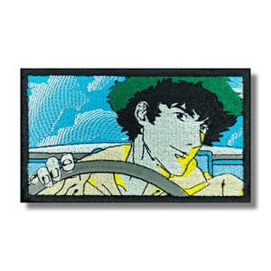 Könnte beinhalten: Gestickter Aufnäher mit einem Anime-Charakter, der ein Auto fährt. Die Figur hat grüne Haare und trägt ein gelbes Hemd. Der Hintergrund zeigt einen blauen Himmel mit weißen Wolken. Der Aufnäher hat einen schwarzen Rand.