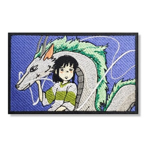 May include: An embroidered patch featuring a white dragon with green accents and a young girl with brown hair wearing a white and green striped shirt. The dragon is breathing out white smoke and the background is a light blue color.