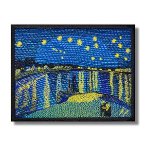 May include: Embroidered patch depicting a starry night sky with a yellow crescent moon and a town in the distance. The sky is a deep blue with yellow stars and the town is outlined in yellow. The patch is ideal for adding a touch of art to your belongings.