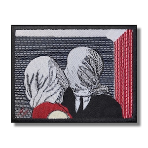 Könnte beinhalten: Gestickter Patch mit einem Schwarzweißbild von zwei Personen, deren Gesichter bedeckt sind, die vor einer rot-weiß gestreiften Wand stehen. Der Patch ist von einem schwarzen Rand umgeben.