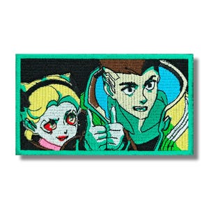 Può includere: Toppa ricamata con due personaggi in stile anime. Uno ha i capelli gialli e gli occhi rossi, l'altro ha i capelli castani e fa il pollice in su. La toppa ha un bordo verde.