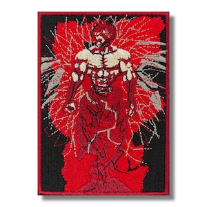 Könnte beinhalten: Gestickter Aufnäher mit einer roten und weißen Figur mit muskulösem Körperbau, umgeben von roten und weißen Flammen. Die Figur hat einen grimmigen Ausdruck und ist vor einem schwarzen Hintergrund platziert.