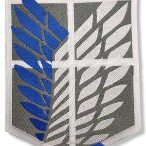 Może przedstawiać: Naszywka haftowana w kolorze szarym i białym z wzorem niebieskiego skrzydła. Naszywka przedstawia stylizowane skrzydło z białym obramowaniem i niebieskim wnętrzem. Naszywka jest otoczona białą ramką.
