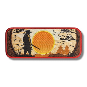 Puede incluir: Parche bordado con la silueta de un samurái de pie frente a un gran sol naranja con pájaros volando por encima. El fondo es un paisaje marrón y beige con árboles y hierba.