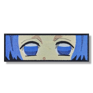 Puede incluir: Parche bordado con un primer plano de los ojos de un personaje de anime de dibujos animados. Los ojos son grandes y azules con pupilas blancas. El personaje tiene el pelo azul y un tono de piel claro.