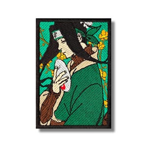 May include: Embroidered patch featuring a character with long black hair, a green headband, and a green robe. The character is holding a white mask with a red accent. The background is teal with yellow floral accents.