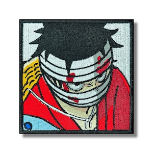 Könnte beinhalten: Gestickter Aufnäher mit einem Anime-Charakter mit schwarzen Haaren und einem bandagierten Gesicht. Das Design verwendet Rot und Weiß mit gelben und blauen Akzenten, eingefasst in einen schwarzen Rahmen. Ein quadratischer Aufnäher.