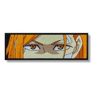 May include: Close-up of a woman's face with orange hair and orange eyes. The woman is looking directly at the viewer.