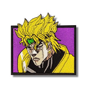 May include: Embroidered patch featuring a character with spiky yellow hair, a green gem, and a stern expression. The character is set against a purple background within a black border. The patch is likely for clothing or accessories.