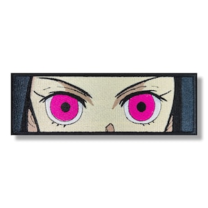 Puede incluir: Parche bordado con un primer plano de un par de ojos de anime. Los ojos son blancos con pupilas negras e iris de color rosa brillante.