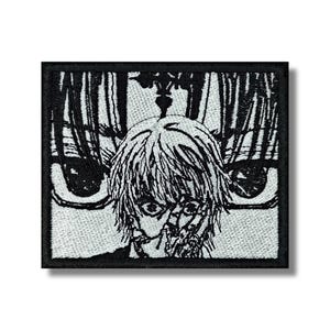 Può includere: Toppa quadrata ricamata in bianco e nero. Presenta un'illustrazione stilizzata di una persona con grandi occhi e un aspetto angosciato. La grafica è dettagliata e in bianco e nero.