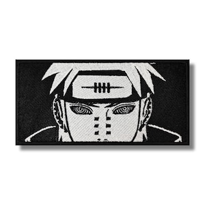 May include: Black and white embroidered patch of a character with a headband that says "IIII" and a white face with black markings. The character has a serious expression and is looking directly at the viewer.