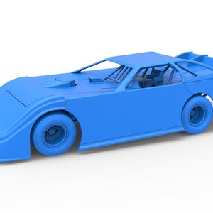 Pode incluir: Modelo de carro de corrida azul claro com perfil baixo, pneus grandes e aerofólio traseiro. O carro tem um interior detalhado visível através das janelas e um design aerodinâmico.