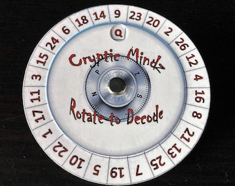 May include: A white and silver cipher wheel with the text "Cryptic Mindz" and "Rotate to Decode" in red. The wheel has numbers around the edge and a rotating dial in the center. A small "Q" is visible.
