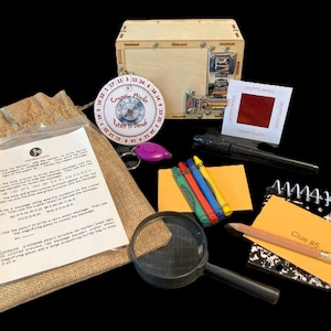 May include: An escape room game kit with a wooden box, a cipher wheel, a magnifying glass, crayons, a notepad, and other puzzle elements. The kit includes a burlap bag with instructions and a key fob. The kit is designed for solving puzzles.