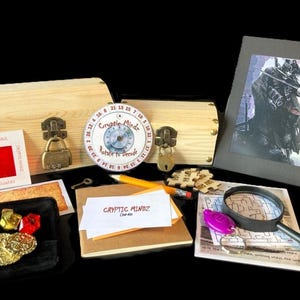 May include: An assortment of items for a mystery game, including two wooden boxes with combination locks, a decoder wheel, a magnifying glass, a map, and a picture of a warrior. The text "CRYPTIC MINDZ" is visible.