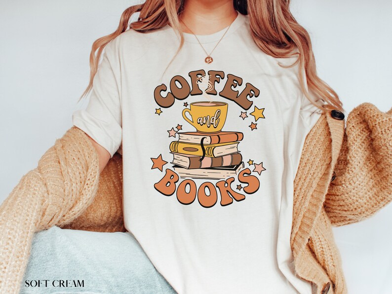 May include: A white t-shirt with the text "Coffee and Books" in brown and orange letters. A cup of coffee and a stack of books are illustrated in the center of the text.