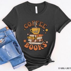 May include: Dark grey heather t-shirt with a retro-style graphic design featuring a coffee cup and books with the text "Coffee and Books".