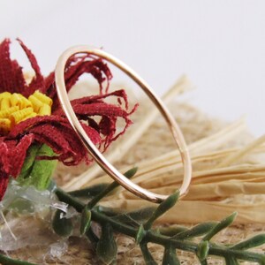 Puede incluir: Un anillo de banda delgado de oro rosa. El anillo es simple y delicado, con un acabado liso y pulido.