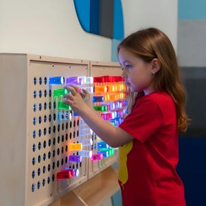 Tablero de pared gigante con clavijas luminosas de colores gigantes (caja de luz sensorial gigante)