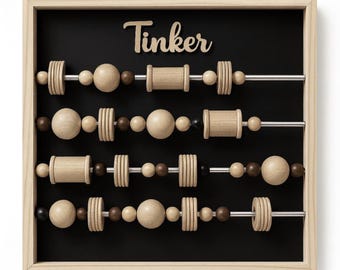 May include: Wooden abacus toy with the word "Tinker" at the top. The abacus has a black background and a light wood frame. The beads are various shapes and shades of brown and tan.