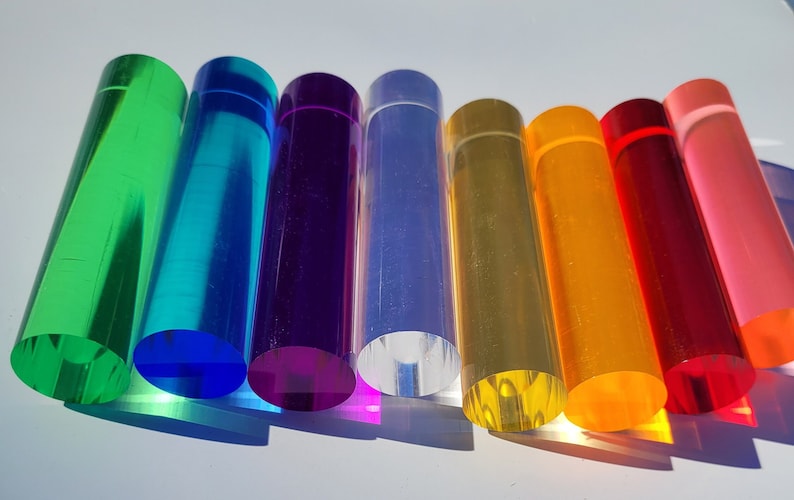 Op de afbeelding: Een set van tien ronde acryl staven in verschillende kleuren, waaronder groen, blauw, paars, helder, geel, oranje, rood en roze. De staven zijn gerangschikt in een regenboogpatroon.