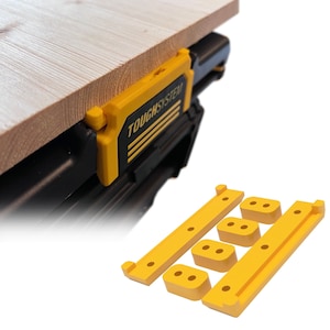 May include: Yellow plastic brackets for attaching a work surface to a black ToughSystem toolbox. The brackets have multiple holes for attaching screws or other fasteners.
