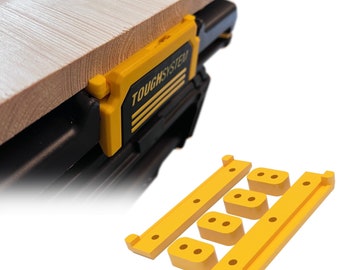 May include: Yellow plastic brackets for attaching a work surface to a black ToughSystem toolbox. The brackets have multiple holes for attaching screws or other fasteners.