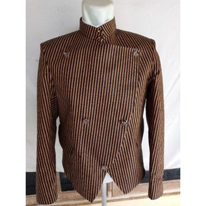Könnte beinhalten: Ein schwarz-brauner gestreifter Blazer mit Stehkragen und einem einzigen Knopfverschluss. Der Blazer hat eine diagonale Vorderseite und silberne Knöpfe.