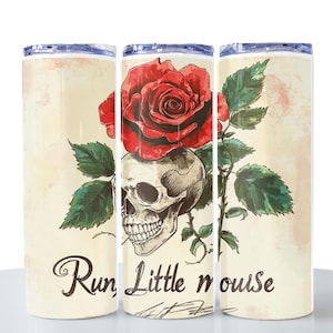 May include: A cylindrical tumbler with a skull and red rose design. The skull is beneath the rose, with green leaves and the words "Run Little mouse" in a script font. The background has a vintage, aged look.