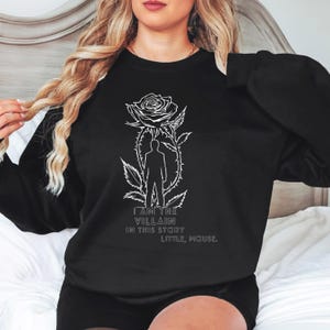 May include: Black sweatshirt with a white graphic of a rose, silhouette, and text. The text reads "I AM THE VILLAIN IN THIS STORY LITTLE, MOUSE." The sweatshirt is a crew neck style.