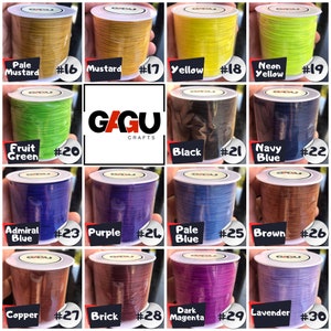 May include: A collection of 15 spools of waxed cord in various colors, including pale mustard, mustard, yellow, neon yellow, fruit green, black, navy blue, admiral blue, purple, pale blue, brown, copper, brick, dark magenta, and lavender. Each spool is labeled with a number from 16 to 30.