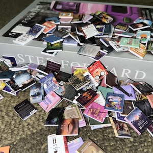Puede incluir: Una gran colecci&oacute;n de libros de bolsillo en miniatura de varios colores y t&iacute;tulos, incluyendo "Me Shatter", "It Happened One Summer", "Red, White & Royal Blue", "The Ruin", "Wings of Fire", "Cleveland, Clueless", "The Last Battle" y "And the Court of Thorns and Roses".