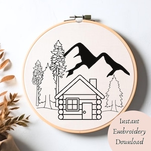 May include: Black and white line art embroidery pattern of a cabin in the woods with mountains in the background. The design includes a cabin with a chimney, a door, and windows, two pine trees, and a mountain range.