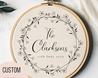 May include: A white embroidery hoop with a black floral wreath design and the text "The Clarksons 12th June 2024".