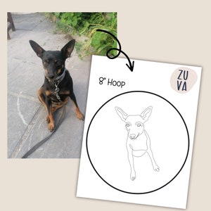 K&ouml;nnte beinhalten: Zeichnung eines schwarzen und braunen Hundes auf einem 20 cm gro&szlig;en Stickrahmen. Der Hund sitzt mit gekreuzten Beinen und geneigtem Kopf. Die Zeichnung ist in Schwarzwei&szlig;.