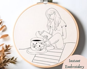 May include: Black and white line art embroidery pattern of a woman sitting with a book and a cup of coffee. The design is in a hoop and says "Instant Embroidery Download" at the bottom.