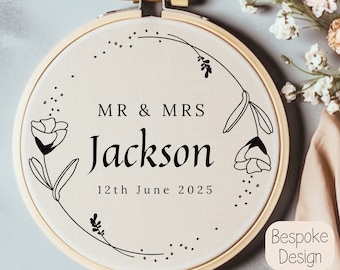 May include: A white embroidery hoop with a black floral design and the text "MR & MRS Jackson 12th June 2025".
